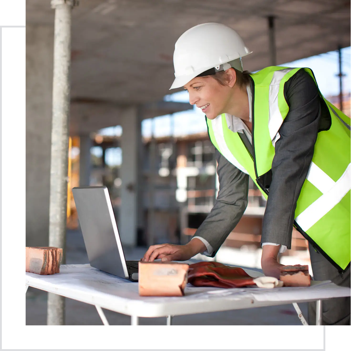 Construction worker using laptop on site.