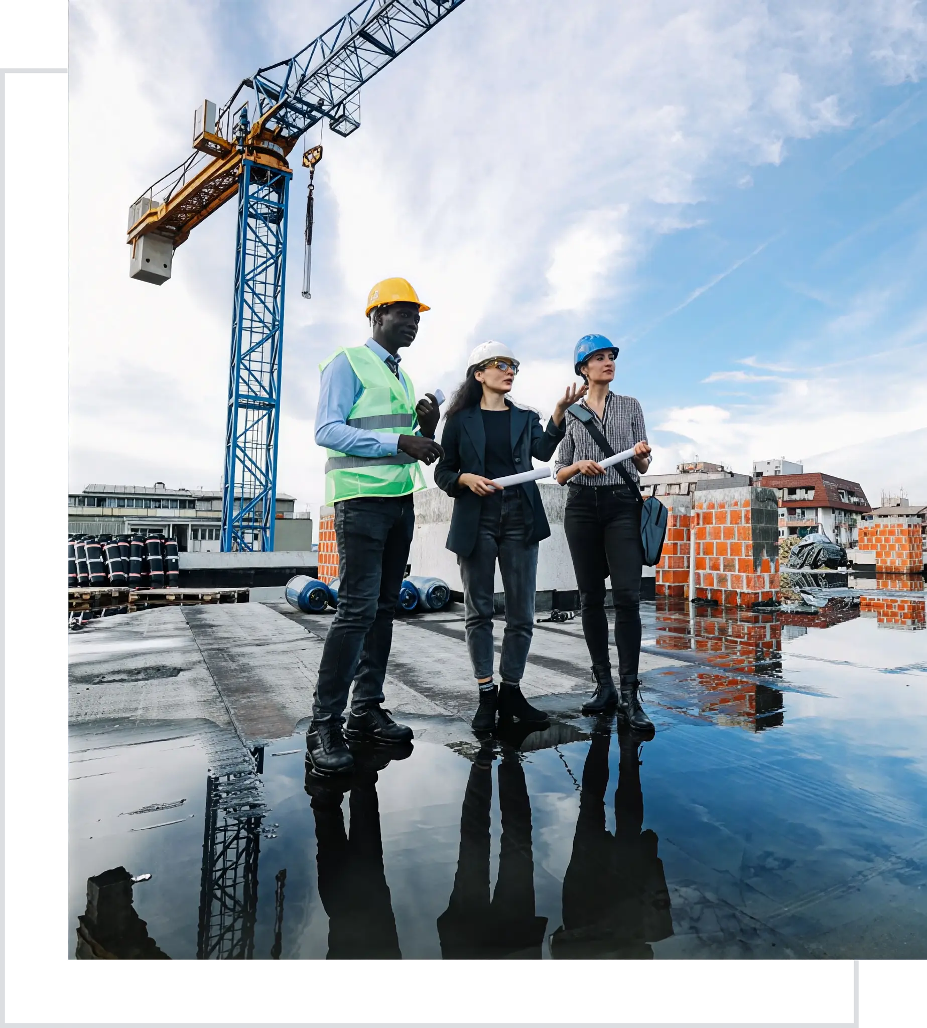 Construction team with blueprints near crane.